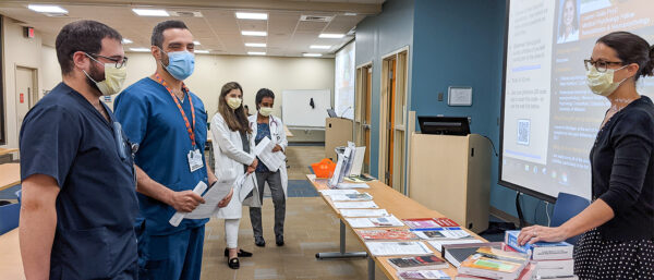 Ryan Avery (from left), Mohammed Al-Nahar, et al, talk with library director Jeni Godlesky, 2021 Hurley GME event